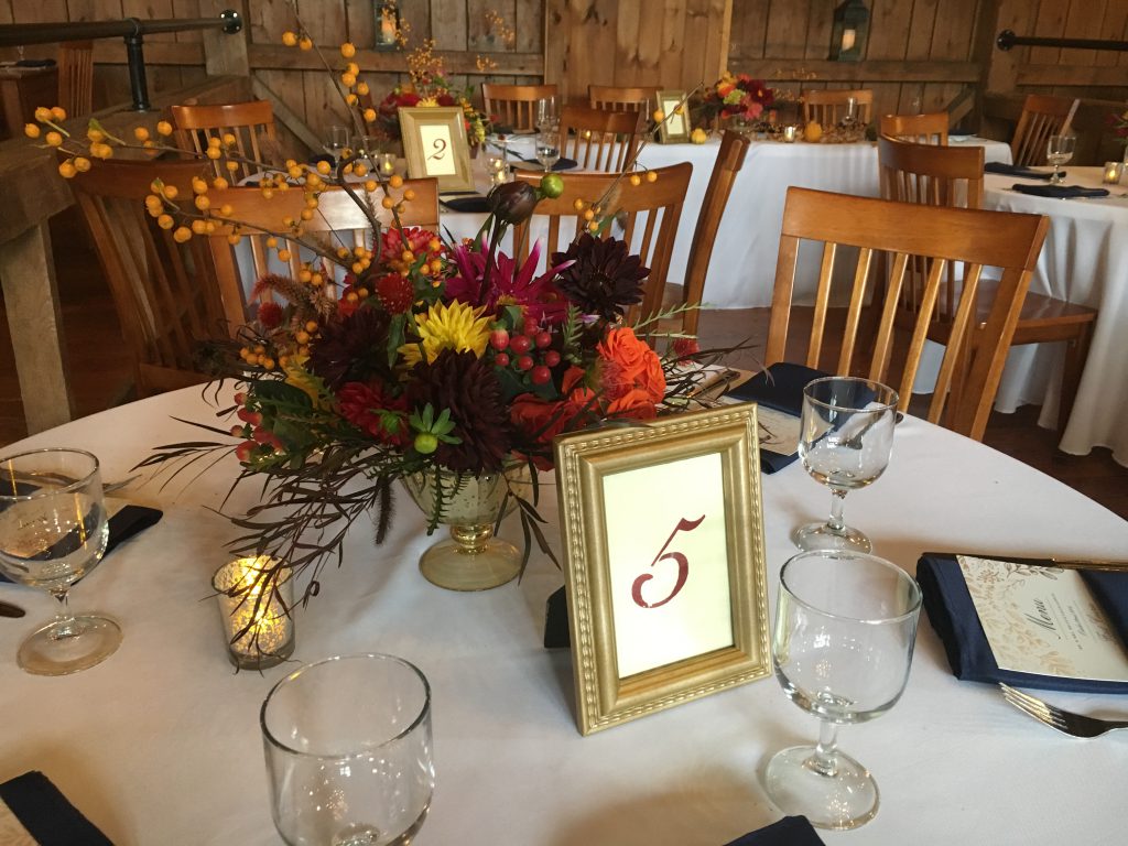 Fall wedding flower centerpieces at a rustic barn wedding venue