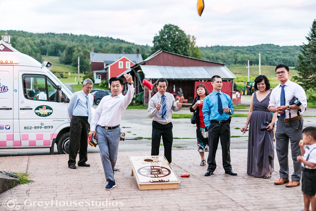 Family playing corn hole at a Vermont outdoor wedding venue