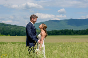 Couple on their wedding day at their wedding venue in Vermont with mountains in the background