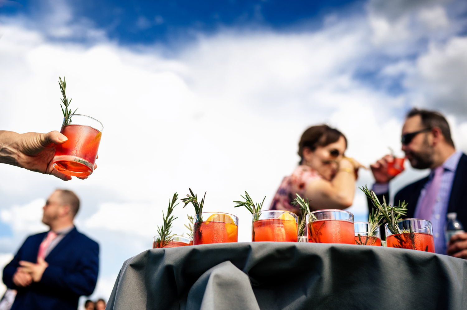 A hand selecting a fruity summer cocktail from a tray at a Vermont wedding