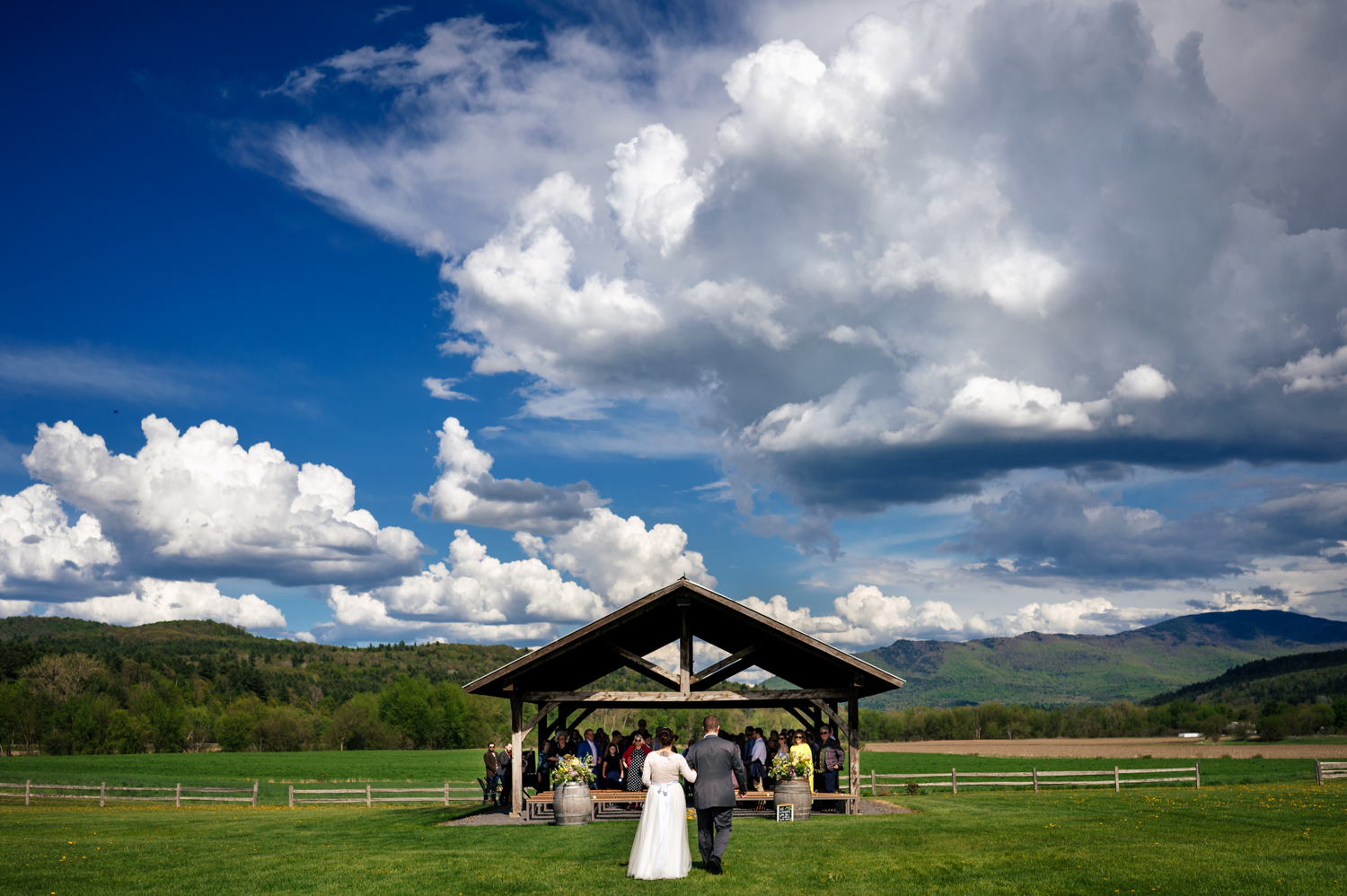 Anne walking to the alter at her outdoor wedding venue with mountain views in the background