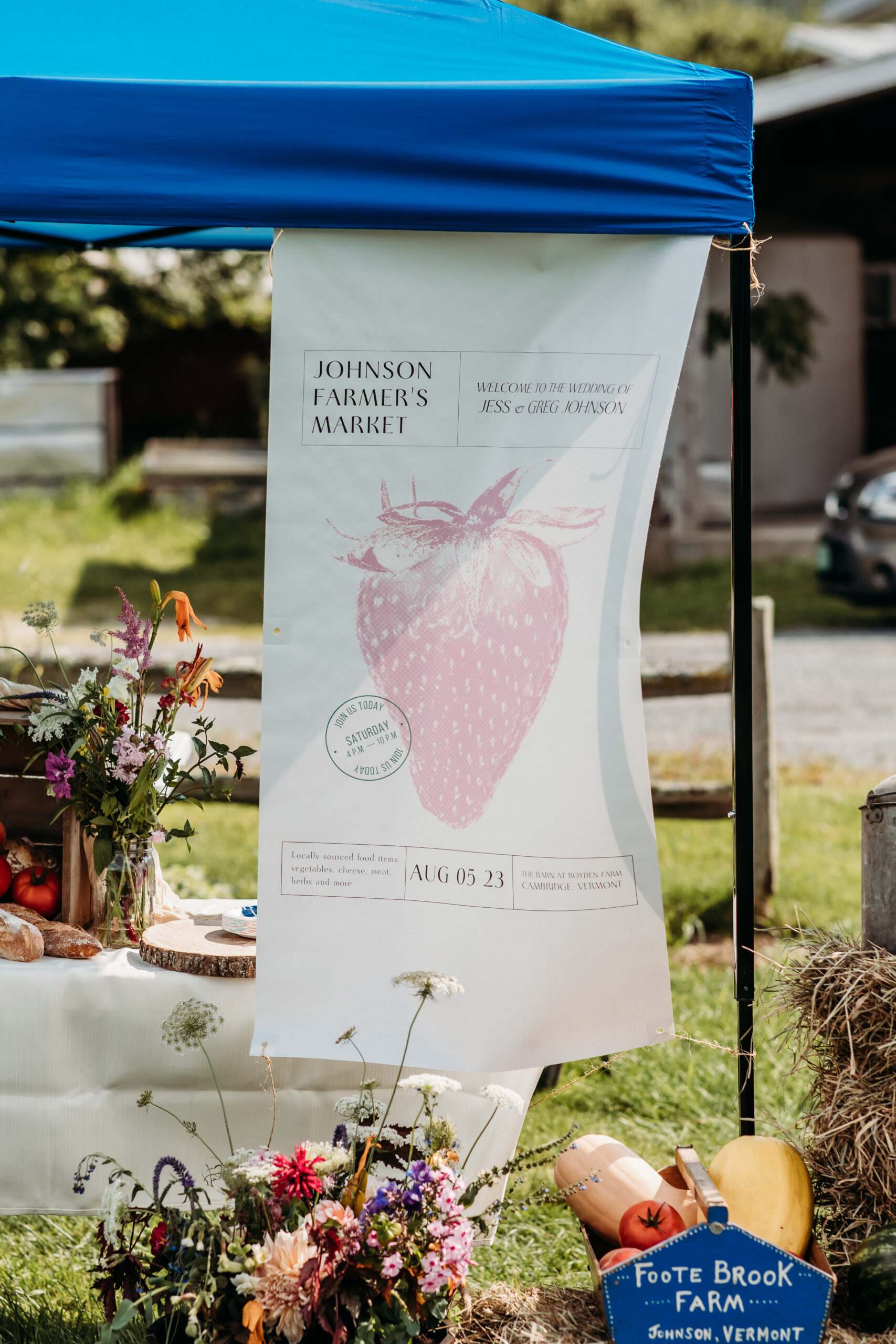 A banner and tent at a stall at Jess and Greg's farmers market themed wedding reception
