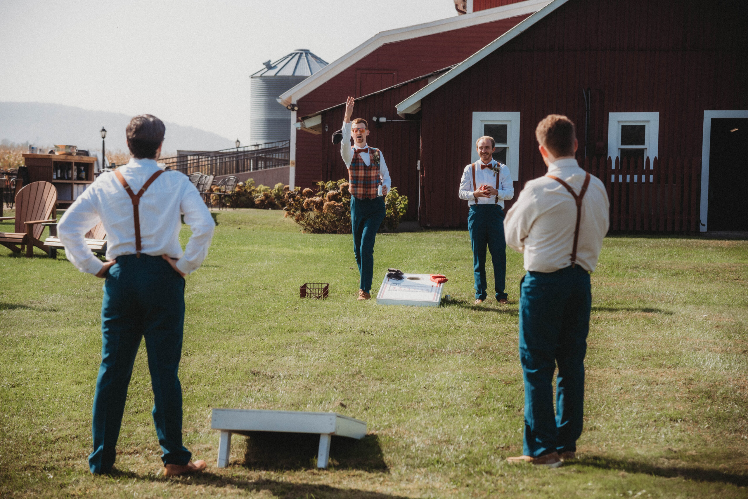 Groom and his groomsmen playing cornhole at an outdoor end of September wedding in Vermont