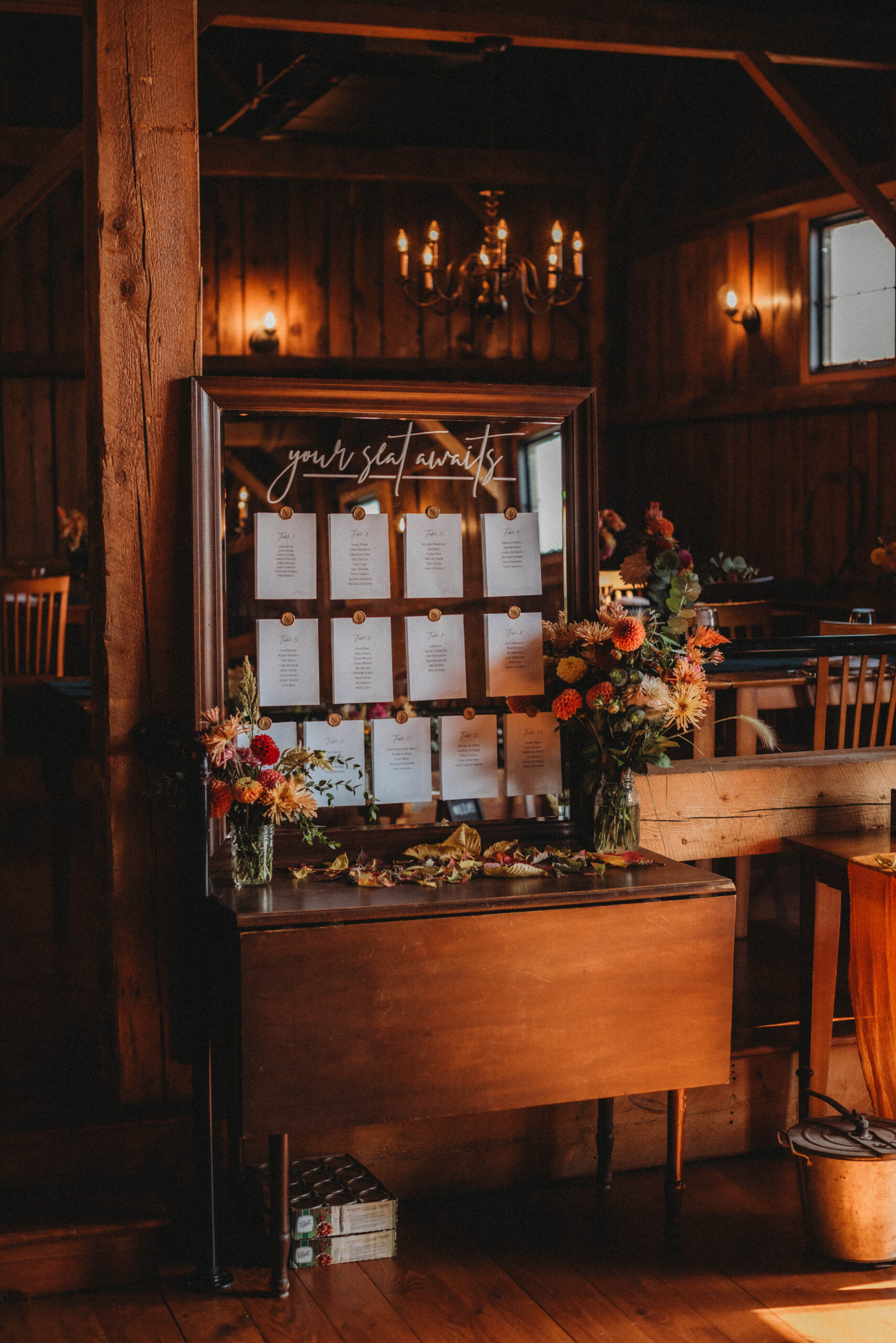 A custom designed mirror with seating chart placements inside the rustic barn venue