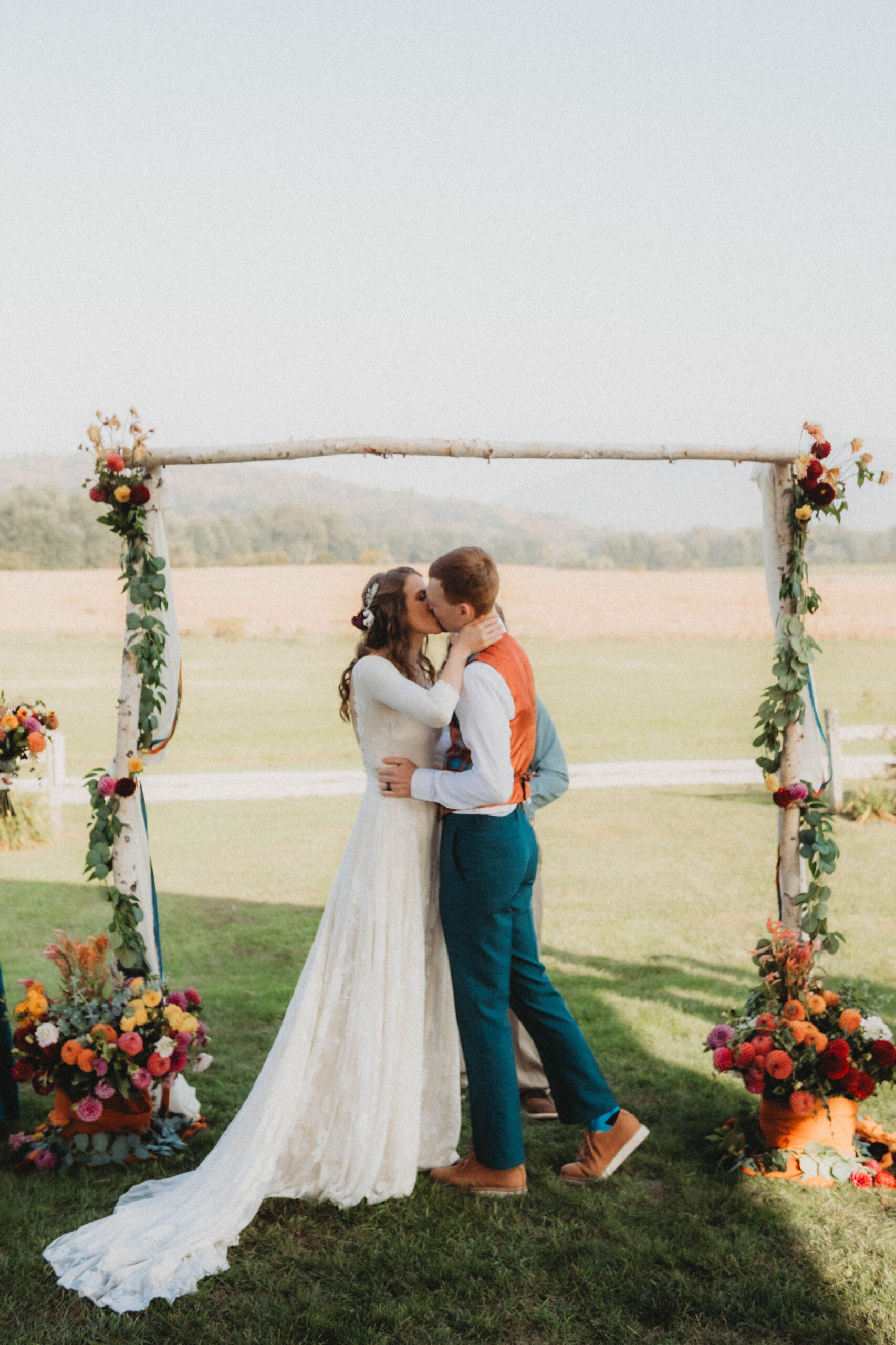 Emily and Sean kissing in front of their wedding arbor