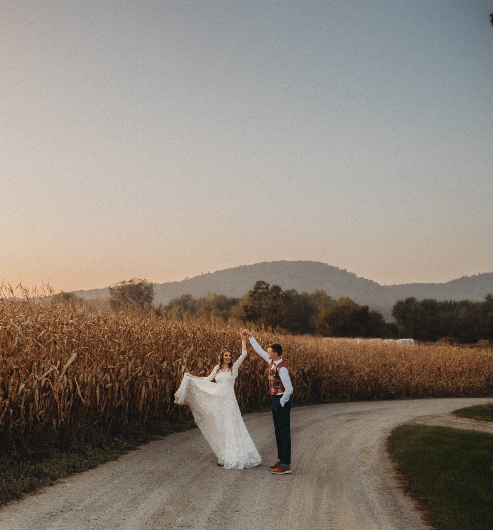 Emily and Sean dancing together in the middle of a dirt road at their Vermont farm wedding venue