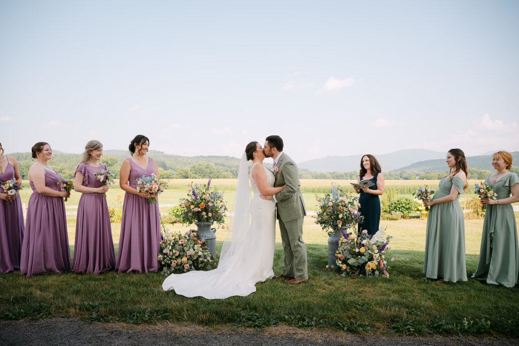 A couple kissing at their wedding at The Barn at Boyden Farm planned by Green Mountain Gatherings